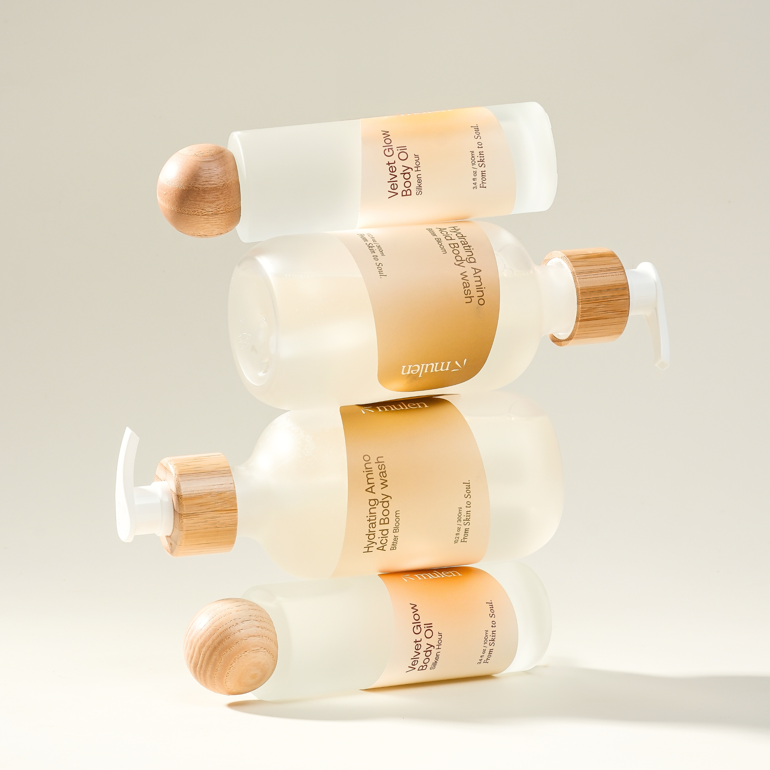 Stack of Unilever body wash bottles with wooden caps on a light background